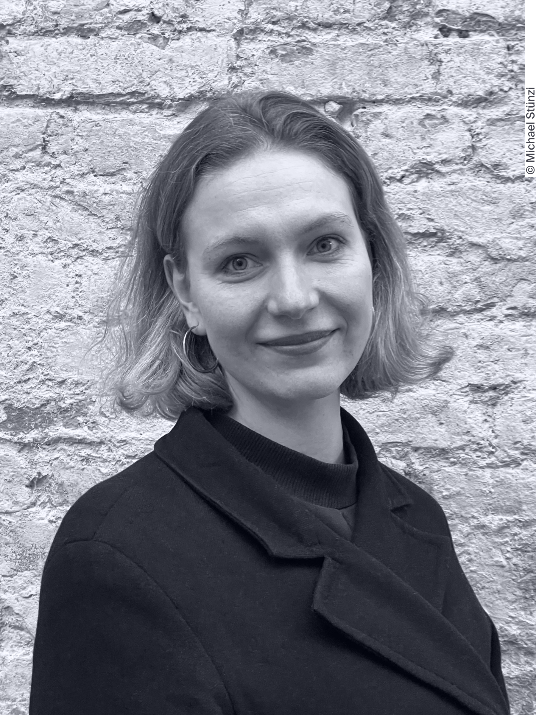 Portait of Laura Knöpfel, Head of Reasearch and Consulting at the SHRI. Ms Knöpfel has middle-length blond hair and clear eyes, and is wearing a black top.