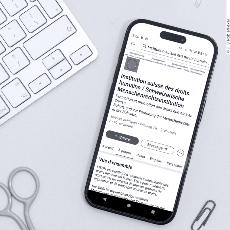 A smartphone on a desk table shows the LinkedIn page of the SHRI.