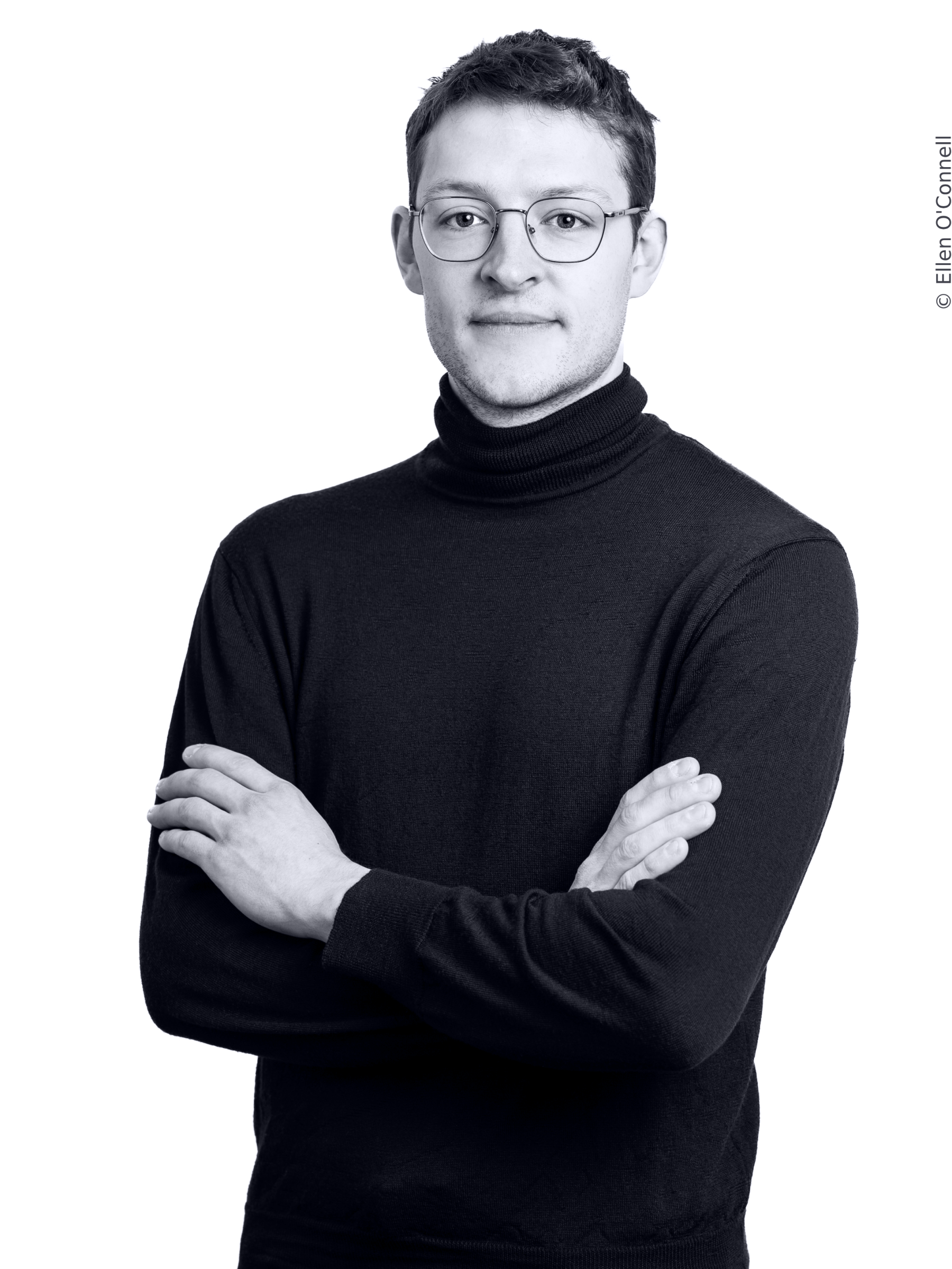 Portrait of Lucien Schönenberg. Mr Schönenberg is a man with short brown hair, wearing glasses and a black turtleneck.
